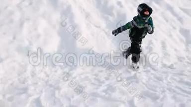 男孩滚下雪山，向前跑.. 侧视。